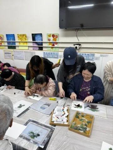 參加者圍在桌邊挑選海玻璃拼砌圖案